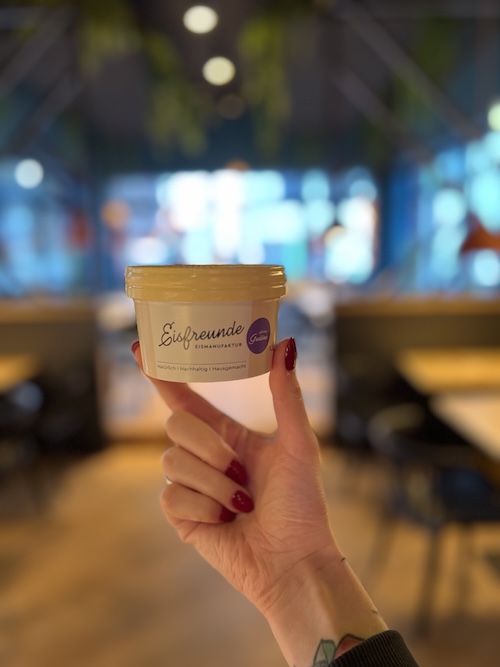 Eisbecher in der Hand